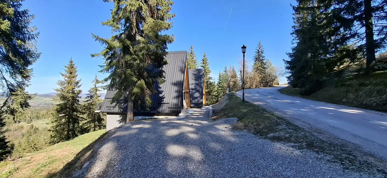 Daytime view of Zečević A-frame cabin with mountain surroundings.
